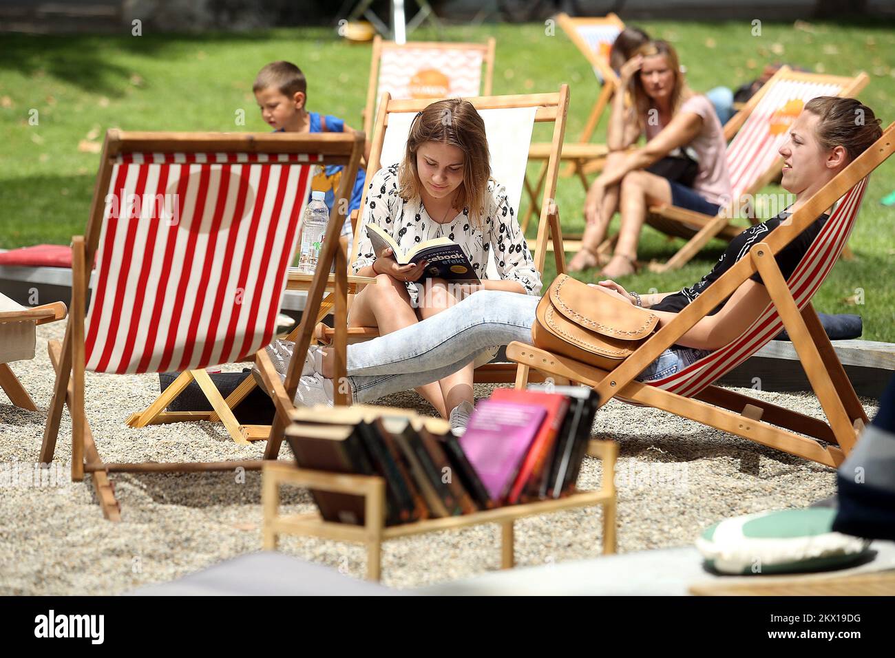 03.07.2017., Zagreb, Croatie - pour la troisième année consécutive, la maison d'édition Lumen organise une foire du livre qui transforme le parc Zrinjevac de Zagreb en une oasis pour les bookworms et les futurs libraires. Le parc est couvert de sable, il y a des parasols et des chaises longues pour que les visiteurs puissent lire plus de 200 livres gratuits à l'ombre, et acheter certains d'entre eux à un prix réduit. Les visiteurs peuvent se rafraîchir avec l'un des cocktails, inspirés par les livres que vous trouverez sur la plage de Lumen. Photo: Goran Stanzl/PIXSELL Banque D'Images