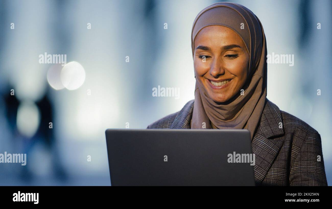 Portrait ethnique islamique musulman d'affaires femme fille internationale étudiant parle vidéo chat conférence en utilisant ordinateur portable parler dans la webcam assis dans Banque D'Images