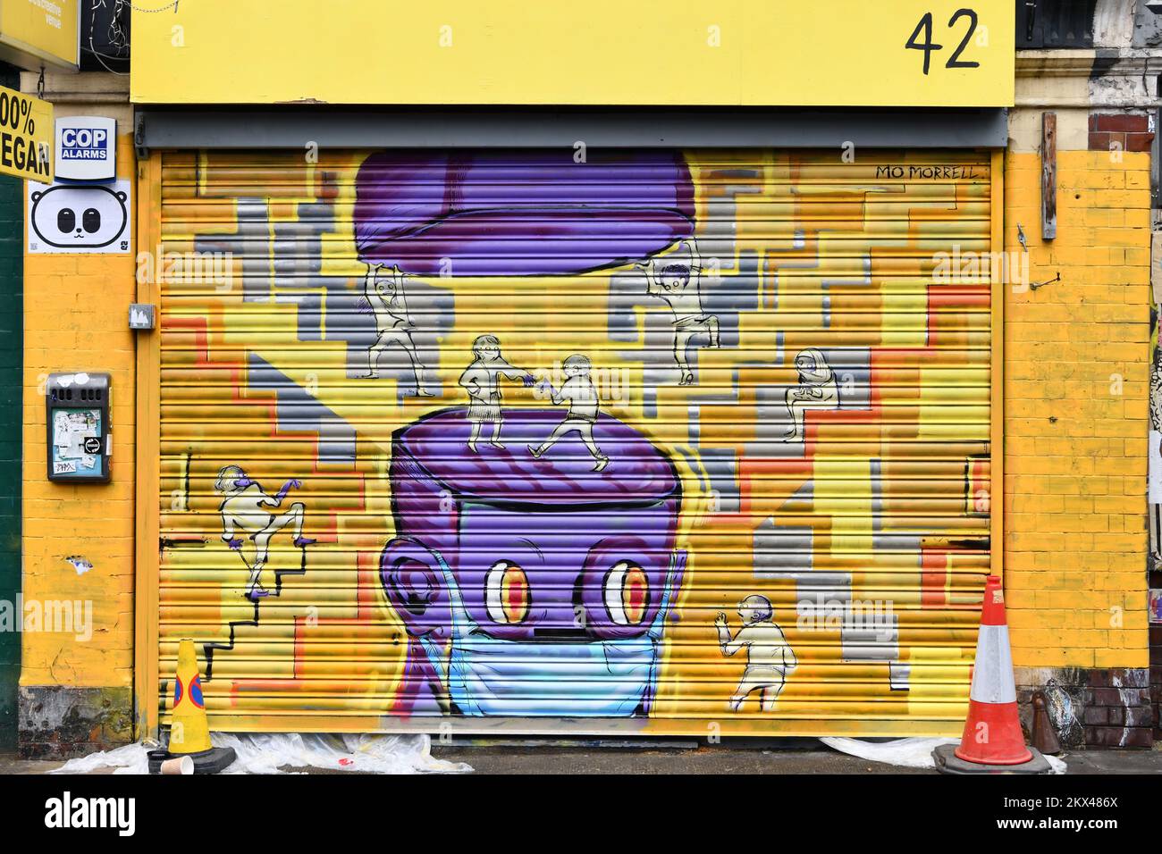 Street art sur les volets jaunes du café fermé, The Canvas, sur Hanbury Street, Shoreditch, Londres Banque D'Images