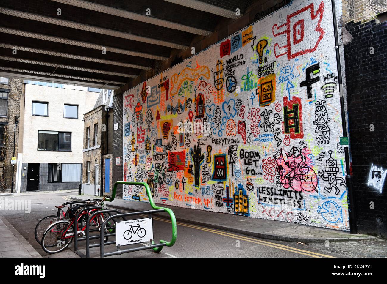 Sélection d'art de rue, de commentaires et de graffiti sur un mur blanc sous le pont ferroviaire sur Dereham place, Shoreditch, Londres Banque D'Images