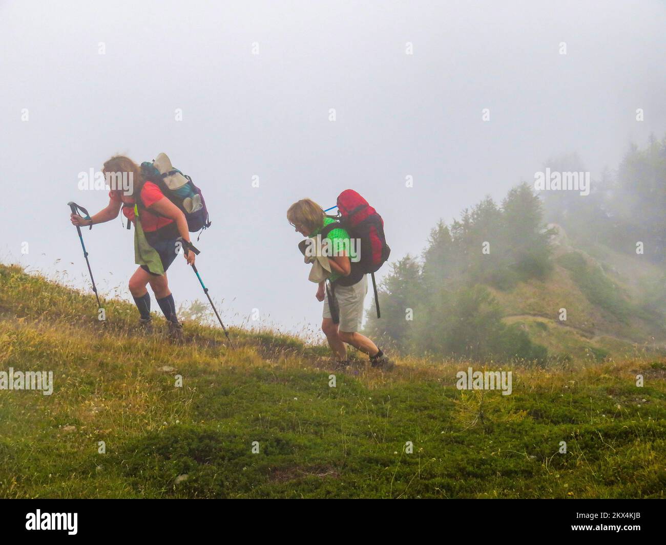 Italie, deux femmes en randonnée dans les Alpes italiennes brumeuses. Banque D'Images