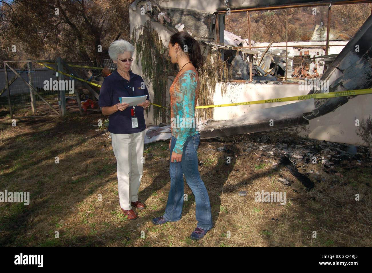 Feu de forêt - Santa Barbara, Californie , Le représentant des relations communautaires de la FEMA (CR) de 29 novembre 2008, Beverly Winder, discute de l'aide à la location avec un résident qui n'était pas assuré et a tout perdu pendant le feu de forêt. Les représentants des CR passent par les quartiers touchés et diffusent des informations sur les programmes de la FEMA directement aux personnes touchées par une catastrophe. . Feux de forêt de Californie. Photographies relatives aux programmes, aux activités et aux fonctionnaires de gestion des catastrophes et des situations d'urgence Banque D'Images