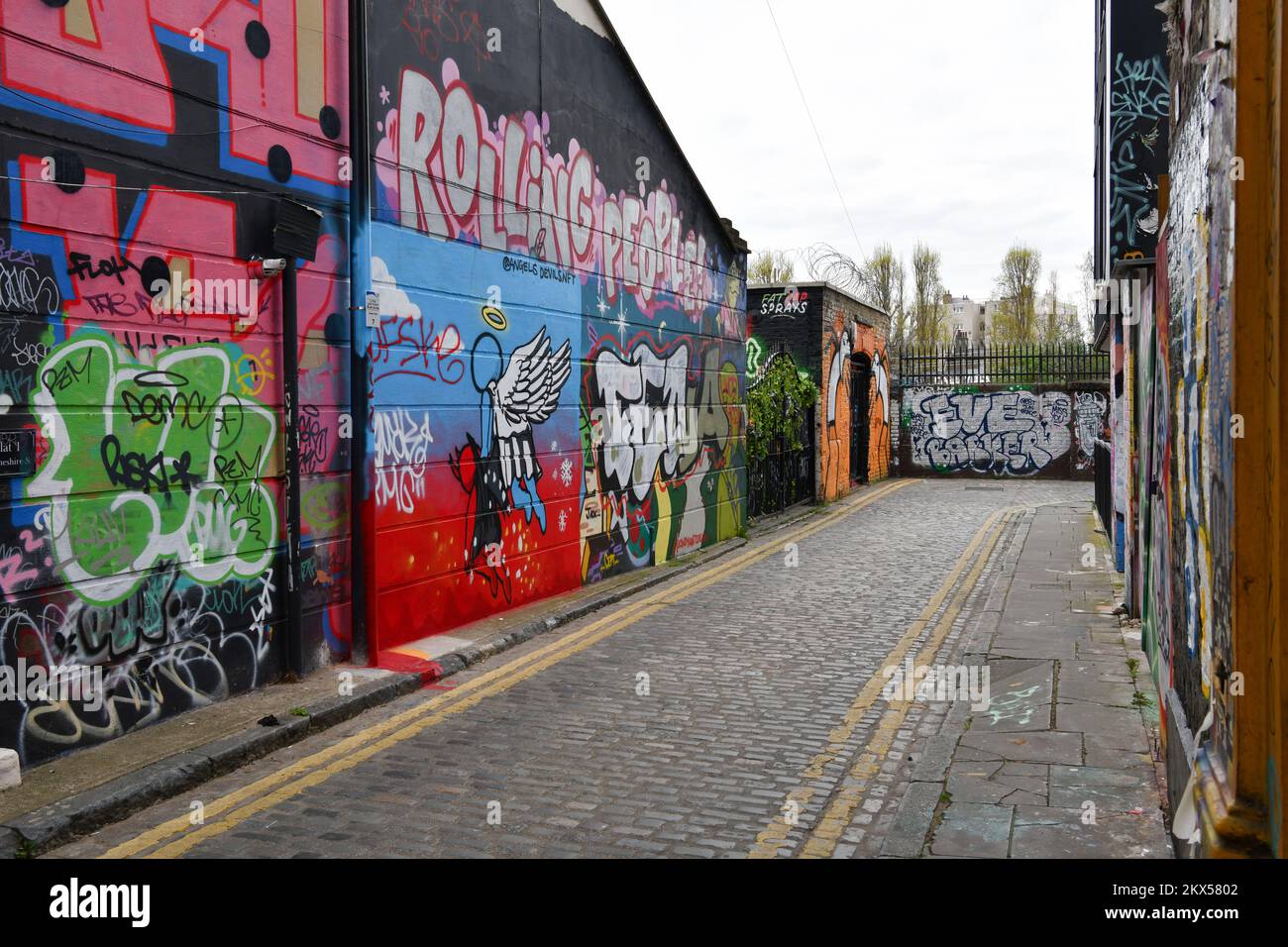 Murs recouverts de graffitis à Grimsby Street, Shoreditch, Londres, y compris 'Shreamers' par l'artiste de rue Stik Banque D'Images