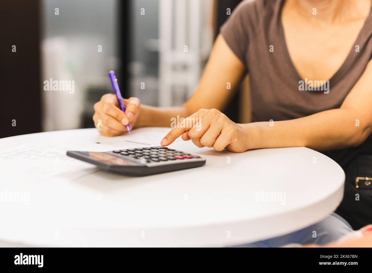 Femme d'affaires tenant le stylet sur la calculatrice pour calculer les données de l'entreprise. Banque D'Images