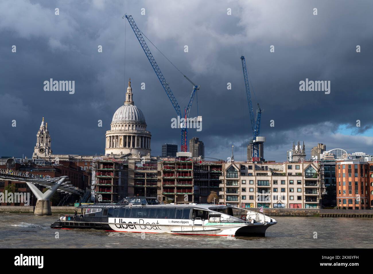 Un Uber Boat by Thames Clippers, bus fluvial passant sous le pont du millénaire avant d'amarrer à Bankside Pier, St. La cathédrale de Pauls est visible dans l' Banque D'Images