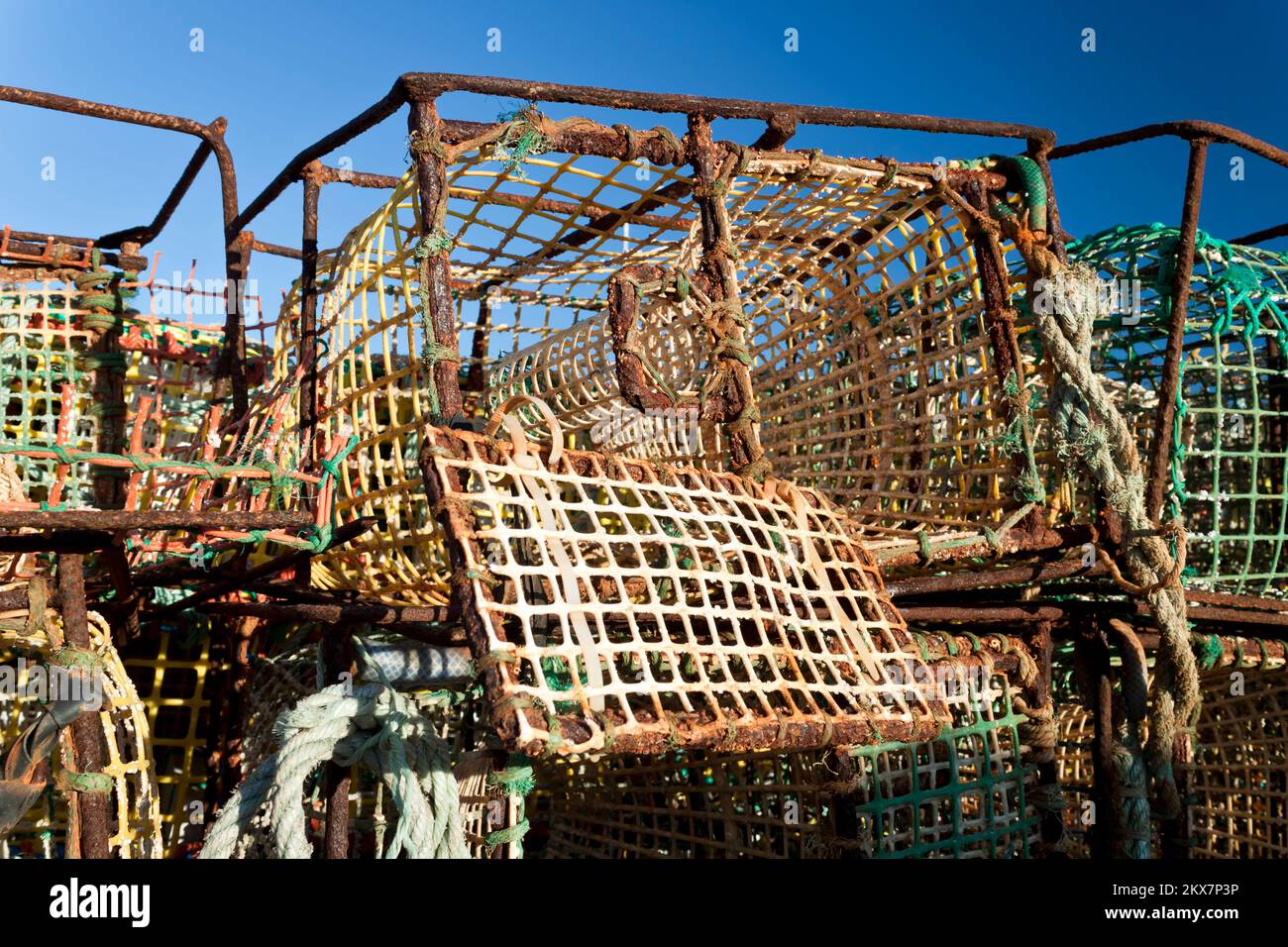 Pile de vieux pots de pêche au crabe sur le front de mer du port de pêche Banque D'Images