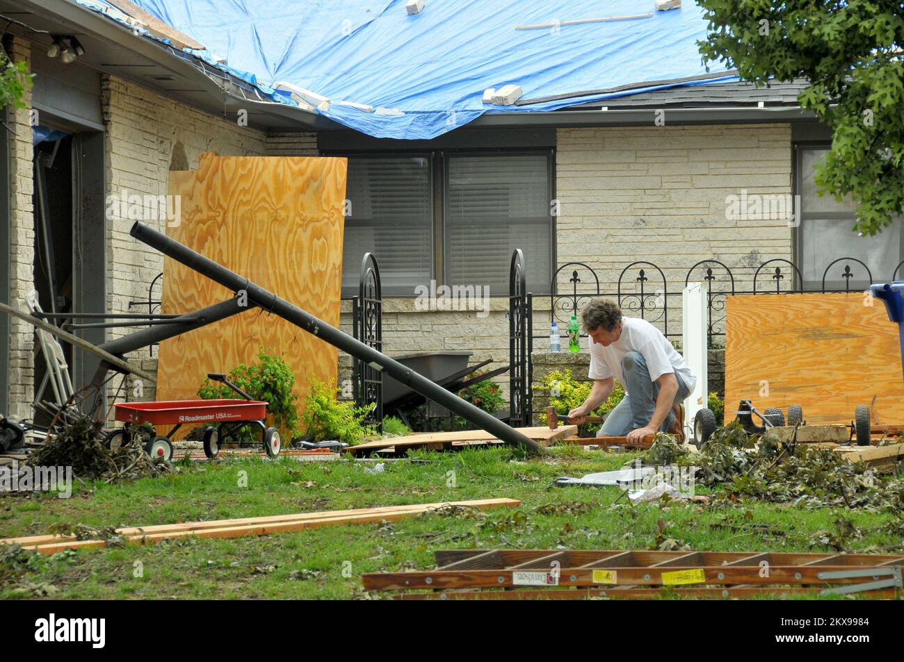 Tempête violente Tornado - Oklahoma City, Oklahoma , 14 mai 2010 Un propriétaire travaille à ramasser les pièces et à réparer les dommages à sa maison causés par une tornade qui a frappé la région sur 10 mai. Une série de tempêtes sévères a produit 22 tornades confirmées ce jour-là. FEMA . Tempêtes de l'Oklahoma, tornades et vents de la ligne droite. Photographies relatives aux programmes, aux activités et aux fonctionnaires de gestion des catastrophes et des situations d'urgence Banque D'Images