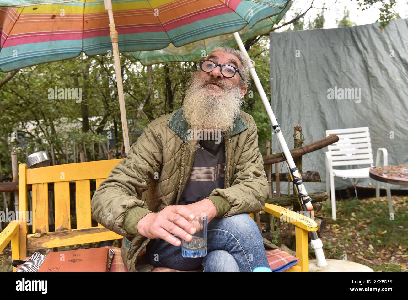 04.11.2019., Umag, Croatie - Alessandro Bumbak (60), peintre et artiste concept vit dans les bois près d'Umag pendant 28 ans. Il n'a pas d'électricité sur son lot forestier de six mille pieds carrés. Il dort dans une vieille caravane, et après des années et des années d'avoir de l'eau dans les seaux des auberges locales ou des amis, il a obtenu de l'eau courante il y a environ un an. Sa compagnie est chien Kira arbres sont ses amis et abri, herbes et une multitude d'installations d'art qui s'étendent partout, le long d'un grand terrain boisé. Sandro utilise de vieux réfrigérateurs comme une salle de stockage pour la vaisselle et les ustensiles ménagers. L'un est même le remplissage Banque D'Images