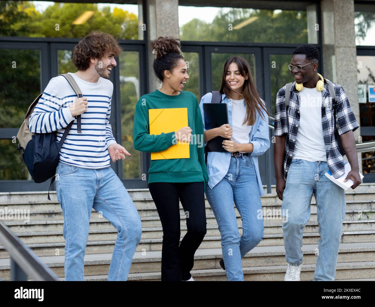 Groupe d'étudiants divers qui parlent les uns aux autres et qui marchent sur le campus Banque D'Images