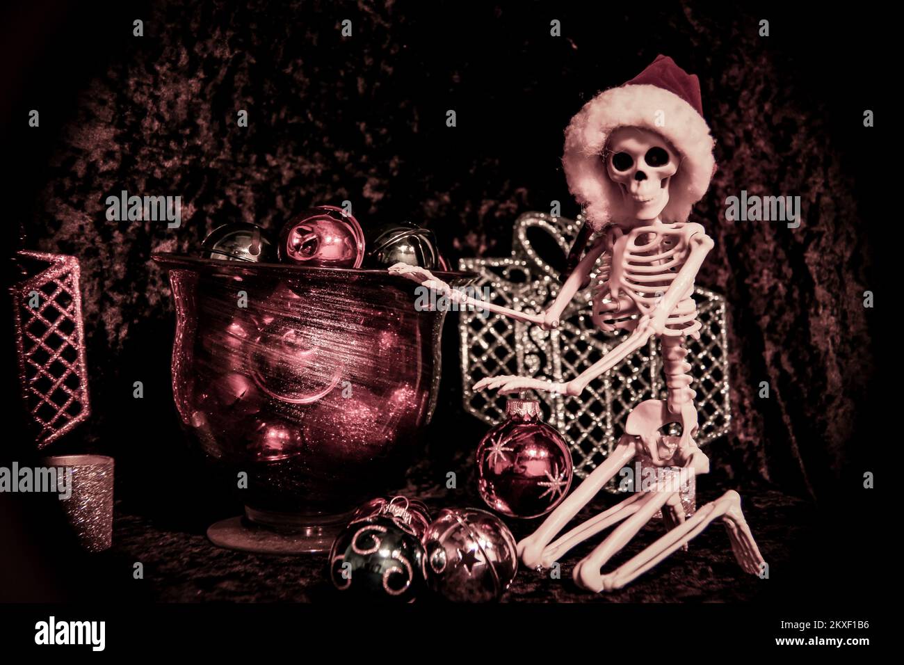 Hiver 2022 - Skeleton portant chapeau de père noël est de trier les boules d'ornement de Noël Banque D'Images