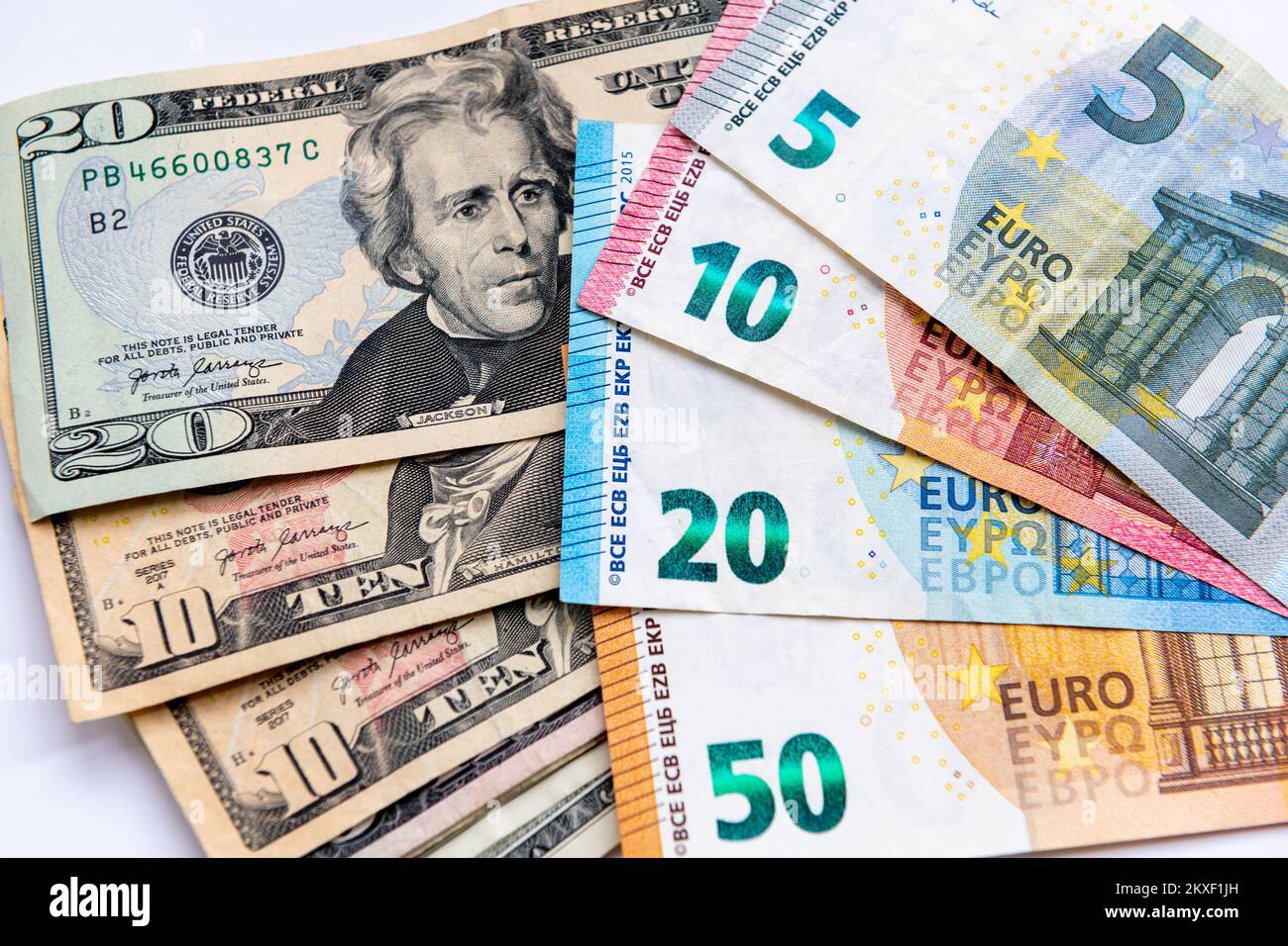 Gros plan des billets en dollars américains et des billets de banque en euros isolés sur fond blanc. Banque D'Images