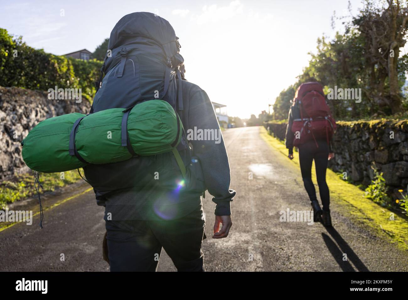 Les personnes qui font de la randonnée avec de grands sacs à dos sur une route dans les Açores Banque D'Images