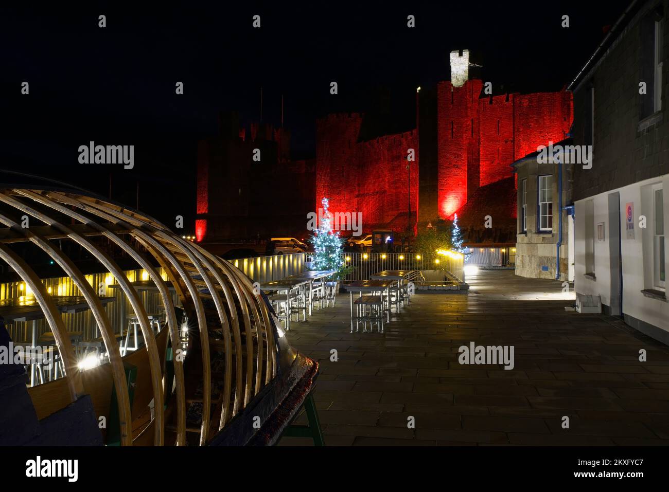 Tour CELF avec le château de Caernarfon, illuminé en rouge pour commémorer l'équipe de football du pays de Galles, coupe du monde 2022, Gwynedd, pays de Galles du Nord, Royaume-Uni, Banque D'Images