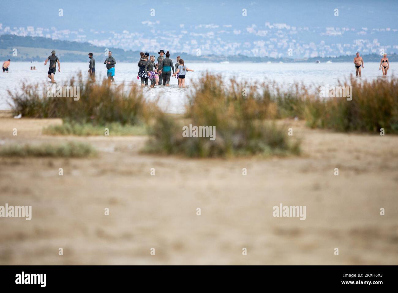 Les gens ont couvert de boue à la plage dans un petit endroit de la Meline, île Krk, Croatie, 14 août,2020. Du début du printemps à la fin de l'automne, la plage du village de Melina est l'une des plus visitées de l'île grâce à la boue curative qui couvre la plage. Les bénéfices de la boue ont été reconnus par beaucoup, en particulier les patients atteints de polyarthrite rhumatoïde qui, après s'être enveloppés de boue, se sentent un grand soulagement.photo: Nel Pavletic/PIXSELL Banque D'Images