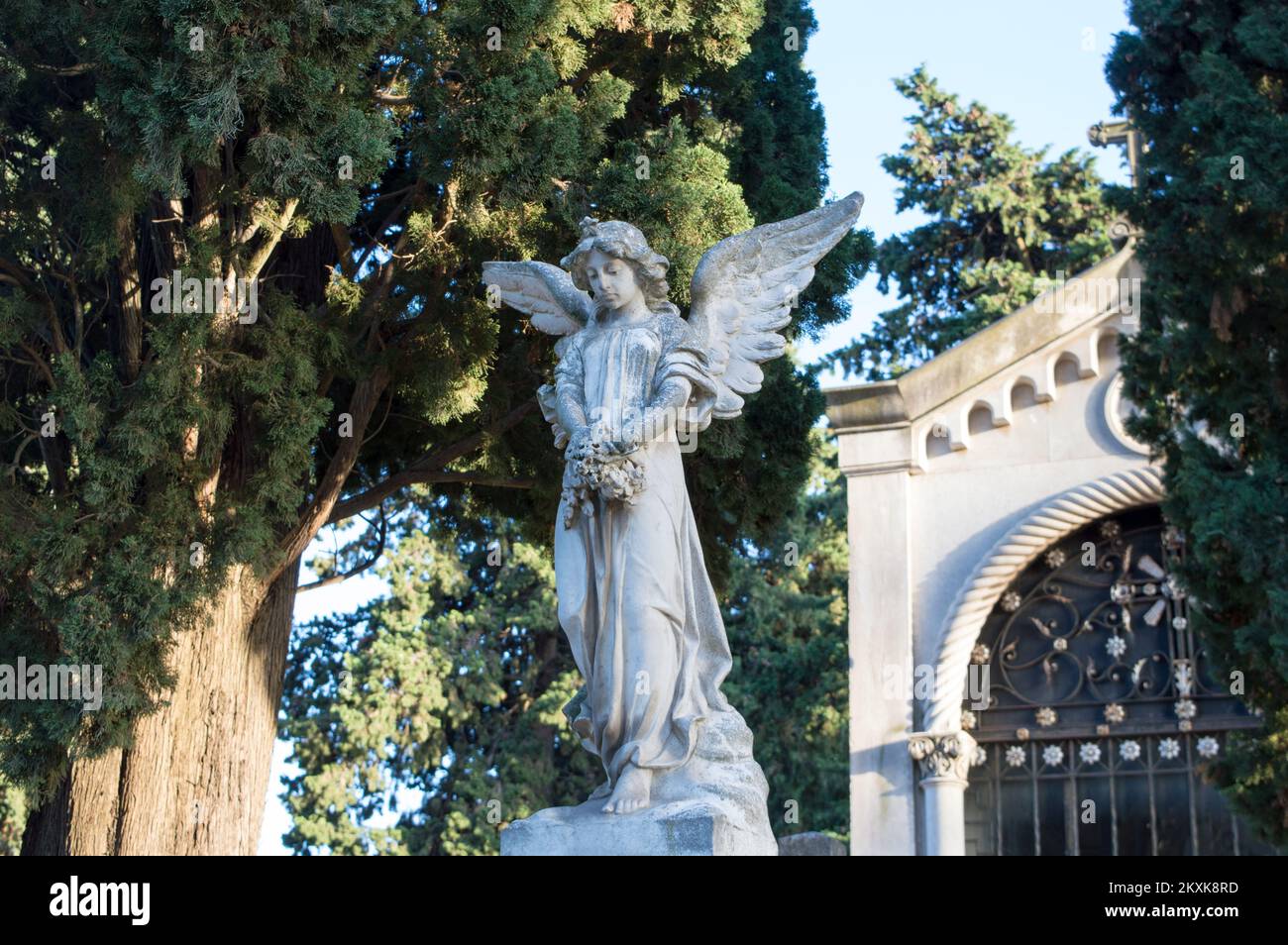 Statue en pierre d'Ange dans le cimetière entouré d'arbres, symbole de grande tristesse Banque D'Images
