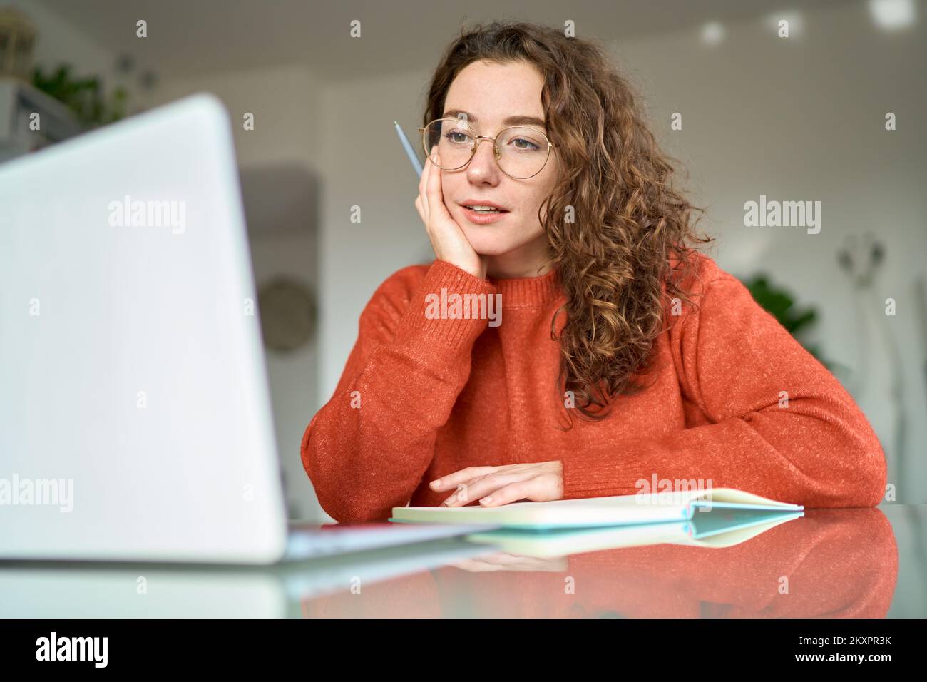 Jeune femme étudiant utilisant un ordinateur portable regardant la rédaction de webinars en ligne à la maison. Banque D'Images