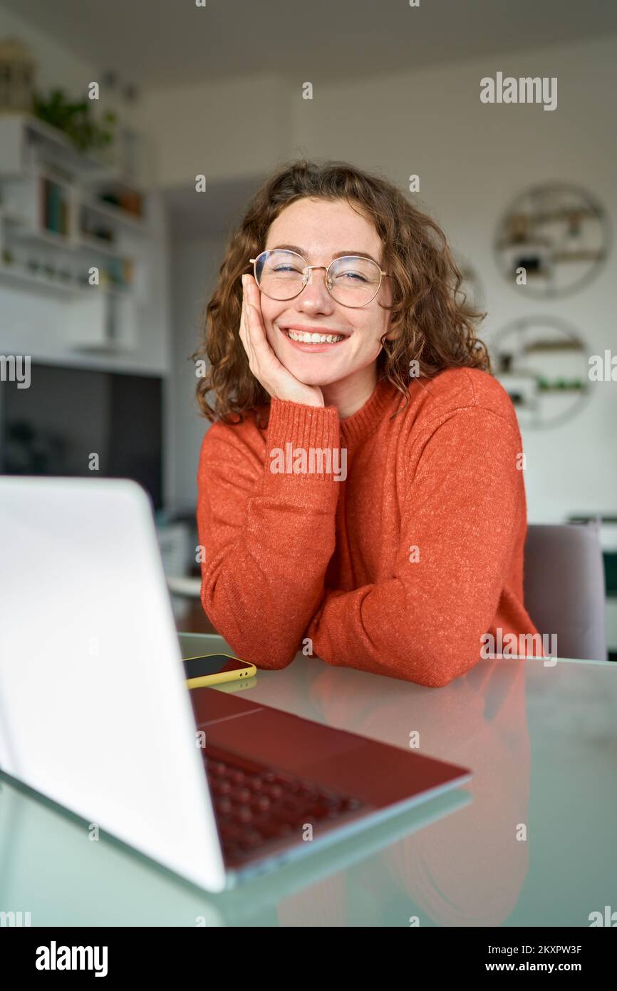 Jeune heureuse jolie femme étudiante assise au bureau à domicile avec ordinateur portable. Portrait Banque D'Images