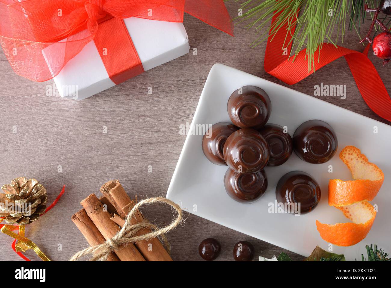 Détail bonbons au chocolat sur une plaque rectangulaire sur une table en bois avec décorations de Noël. Vue de dessus. Banque D'Images