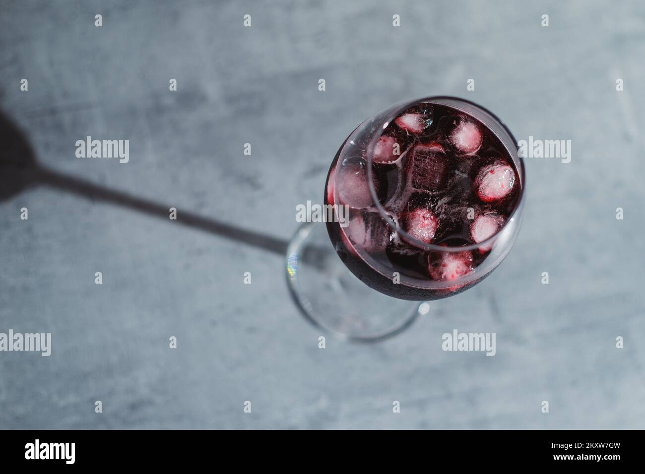 Gros plan dans le vin rouge en verres avec glace sur la table texturée Banque D'Images