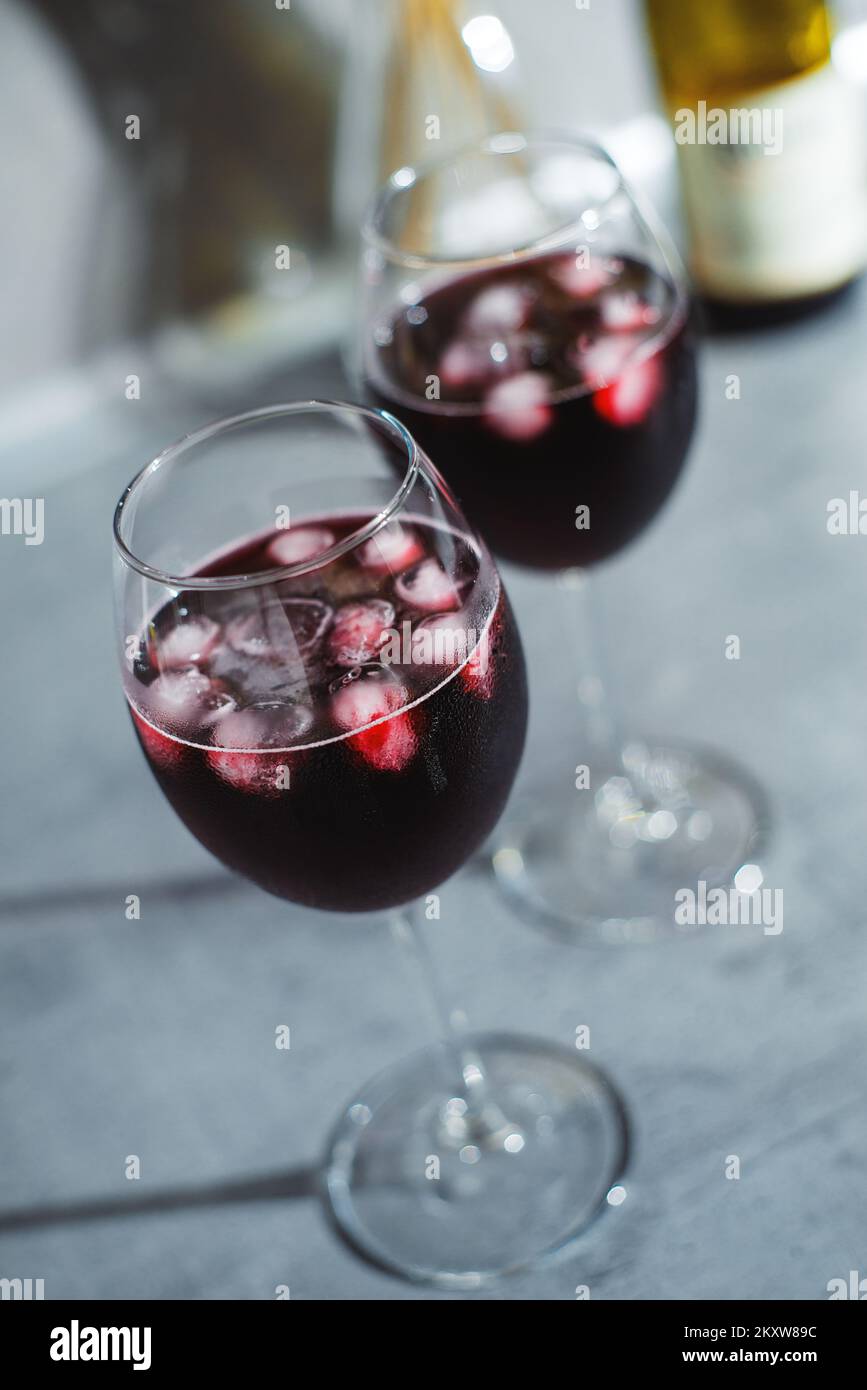 Gros plan dans le vin rouge en verres avec glace sur la table texturée Banque D'Images