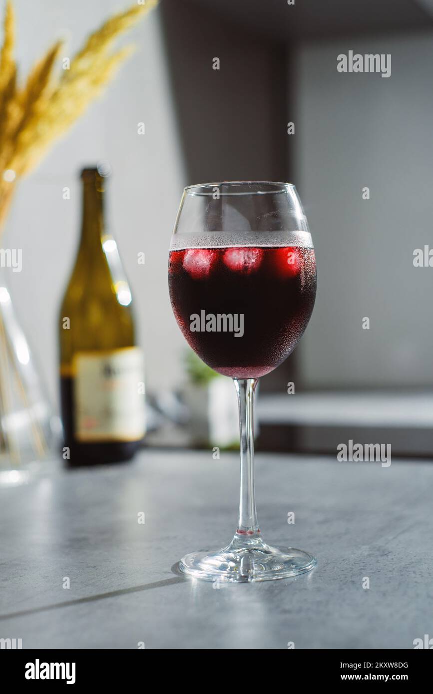 Gros plan dans le vin rouge en verres avec glace sur la table texturée Banque D'Images