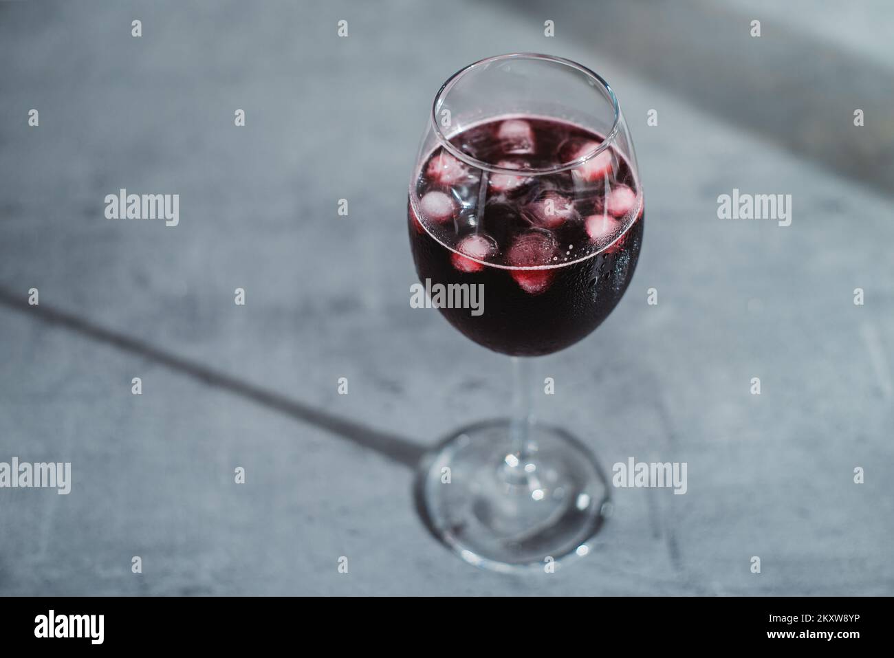 Gros plan dans le vin rouge en verres avec glace sur la table texturée Banque D'Images
