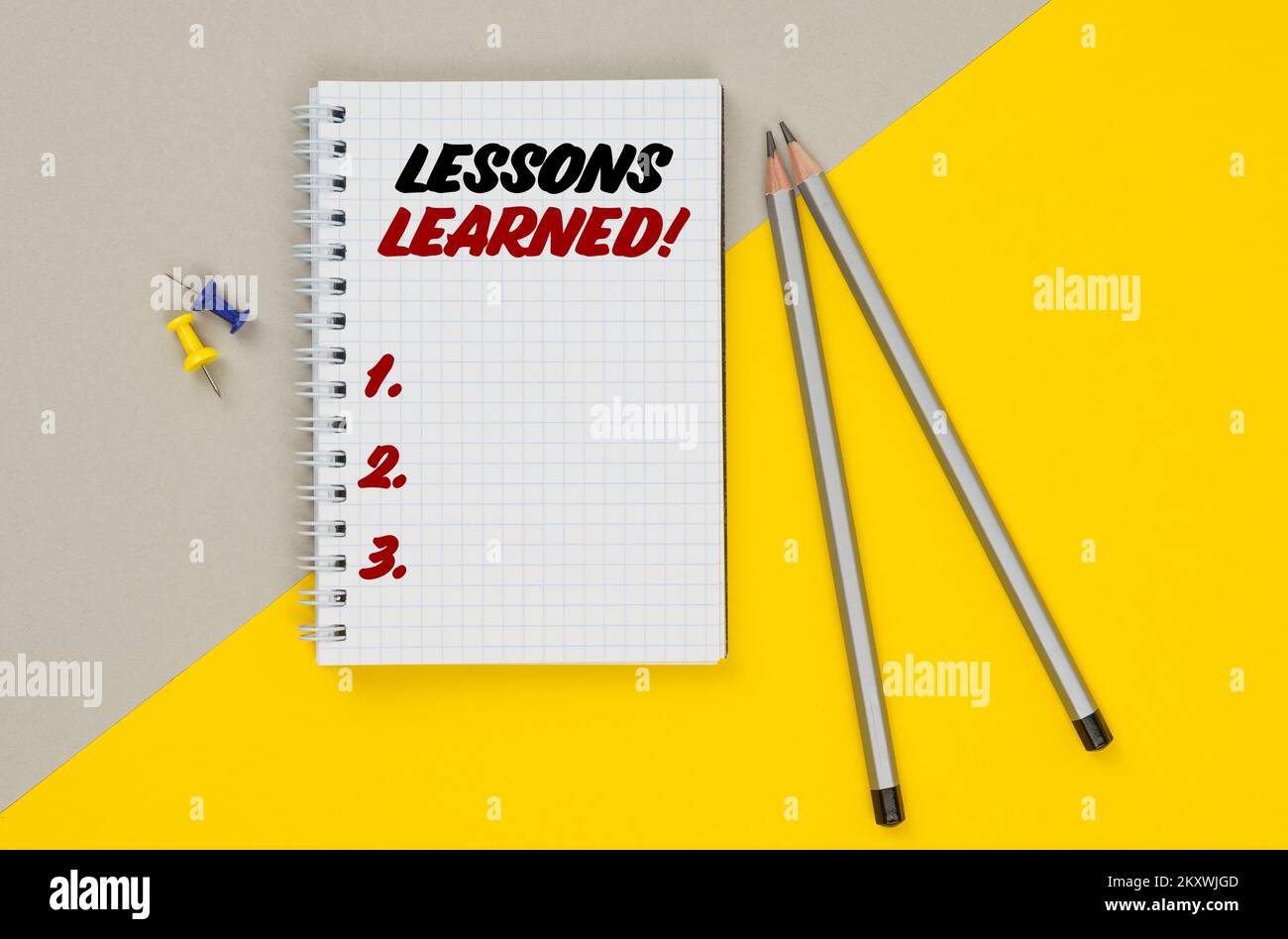 Affaires et finances. Sur un fond jaune-gris sont des crayons, des boutons et un bloc-notes dans lequel il est écrit - leçons apprises Banque D'Images