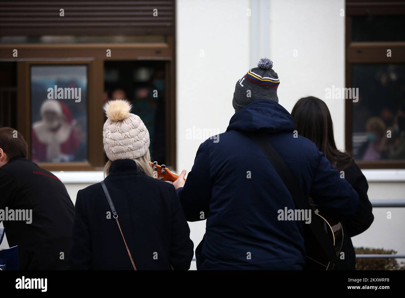 Les gens chantent des chants de Noël et des chansons pour enfants devant les fenêtres du Département d'hématologie pédiatrique, d'oncologie et de transplantation de cellules souches hématopoïétiques du Centre hospitalier universitaire de Zagreb, à Zagreb, en Croatie, sur 23 décembre 2021. Photo: Zeljko Hladika/PIXSELL Banque D'Images