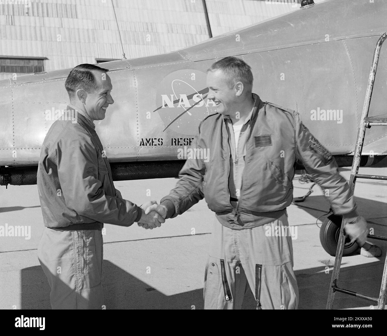 Le pilote d'essai Ames Fred Drinkwater félicite Neil Armstrong de son premier vol stationnaire dans l'avion vertical Ames Bell X-14 Takeoff and Landing (VTOL) au Centre de recherche Ames de la NASA. Photographie du photographe Lee Jones de la NASA. Banque D'Images