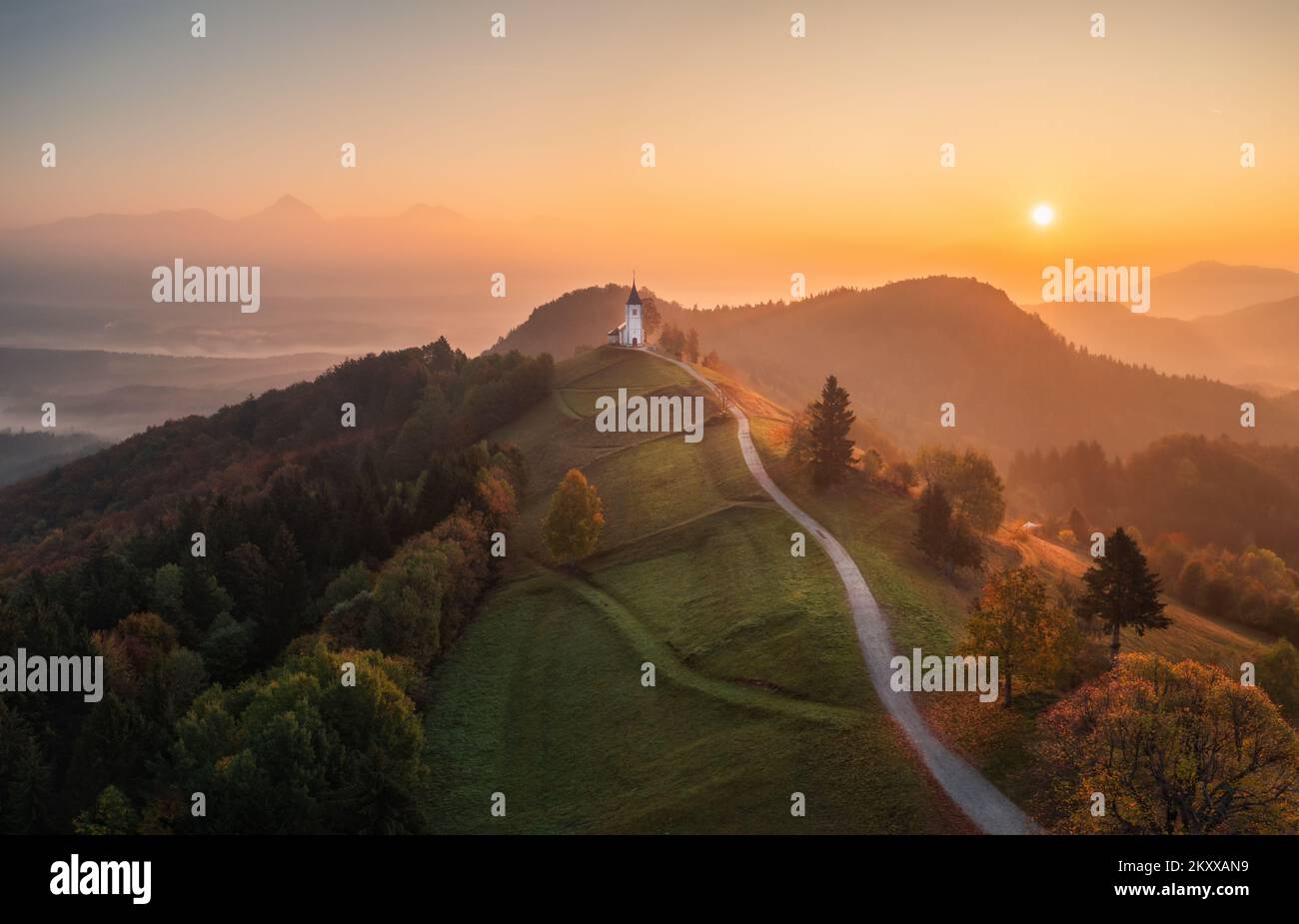 Vue aérienne de drone de petite belle église sur le sommet de la montagne en Slovénie à l'aube magnifique automne matin paysage Banque D'Images