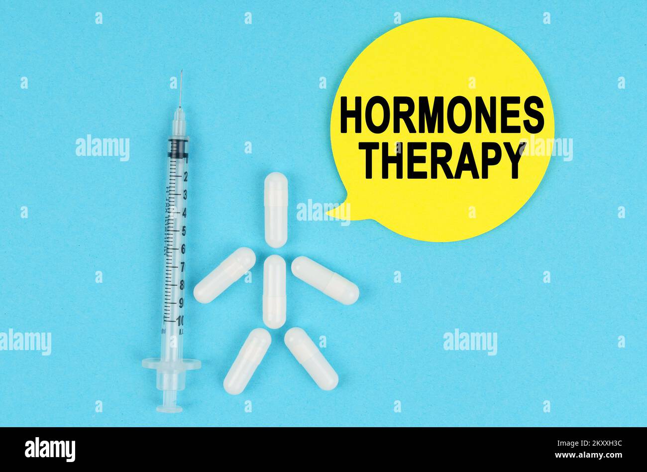 Médecine et concept de santé. Seringue, figure humaine faite de pilules et autocollant en papier avec l'inscription - HORMONOTHÉRAPIE Banque D'Images