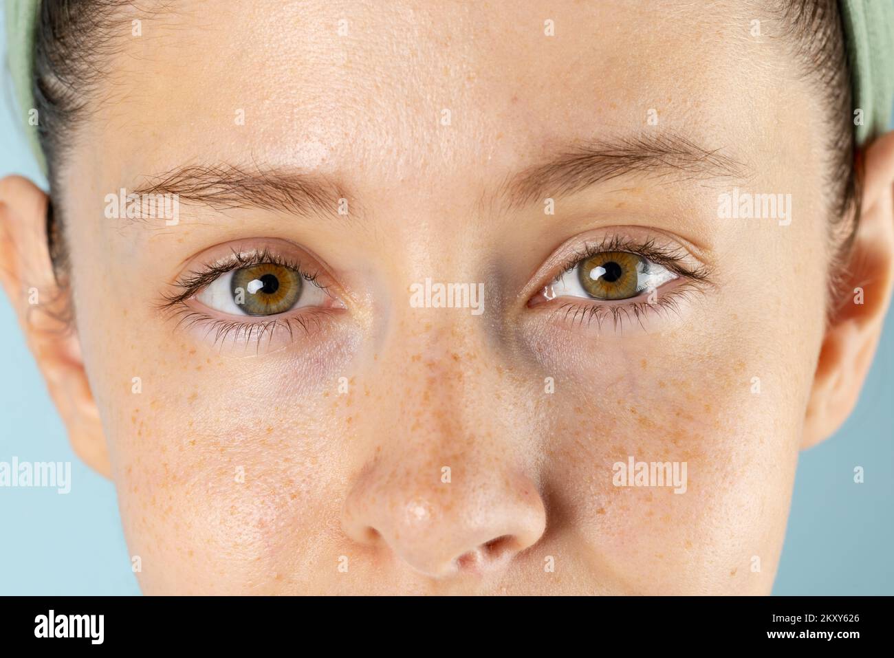 Gros plan des yeux de la femme caucasienne sur fond bleu Banque D'Images