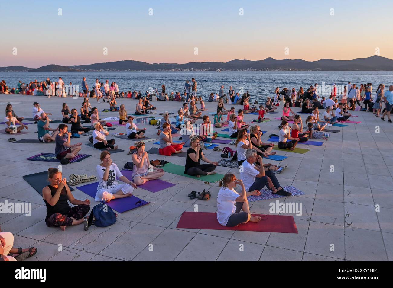 Les gens font du yoga au coucher du soleil à l'orgue de mer pour célébrer la Journée internationale du yoga à Zadar, en Croatie, sur 14 juin 2022. Photo: Dino Stanin/PIXSELL Banque D'Images