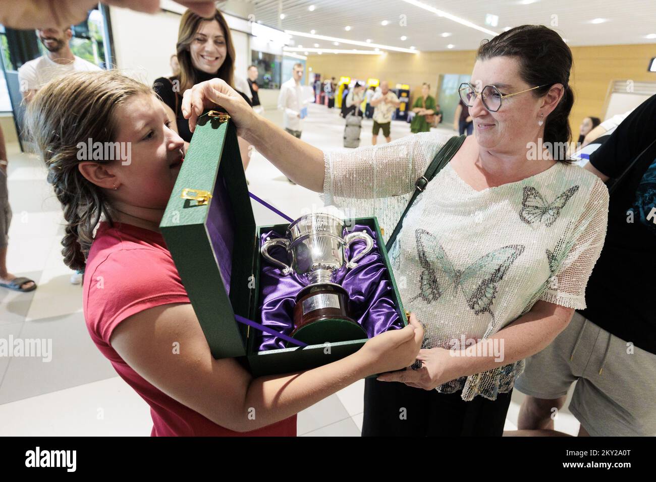 Lors de son retour à l'aéroport de Split à Kastel, en Croatie, sur 11 juillet 2022, la fière mère Nilija et la sœur Petra présentent le trophée du premier Grand Chelem croate à Wimbledon, Mili Poljicak. Mili Poljicak, 17 ans, est devenu le premier croate à remporter le titre de Juniors de Wimbledon. La star montante du tennis chez les adolescents de Split, qui aura 18 ans la semaine prochaine, a battu l'américain Michael Zheng 7:6, 7:6 dans la finale des Championnats juniors 2022 à Wimbledon dimanche. Photo: Miroslav Lelas/PIXSELL Banque D'Images