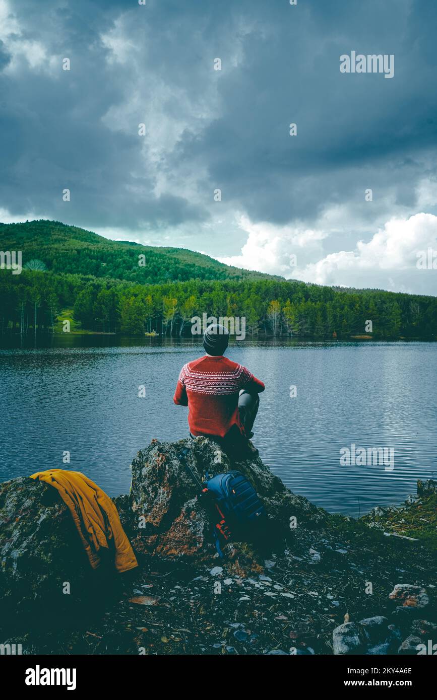Un voyageur regarde la nature au bord du lac. faire du camping. Banque D'Images