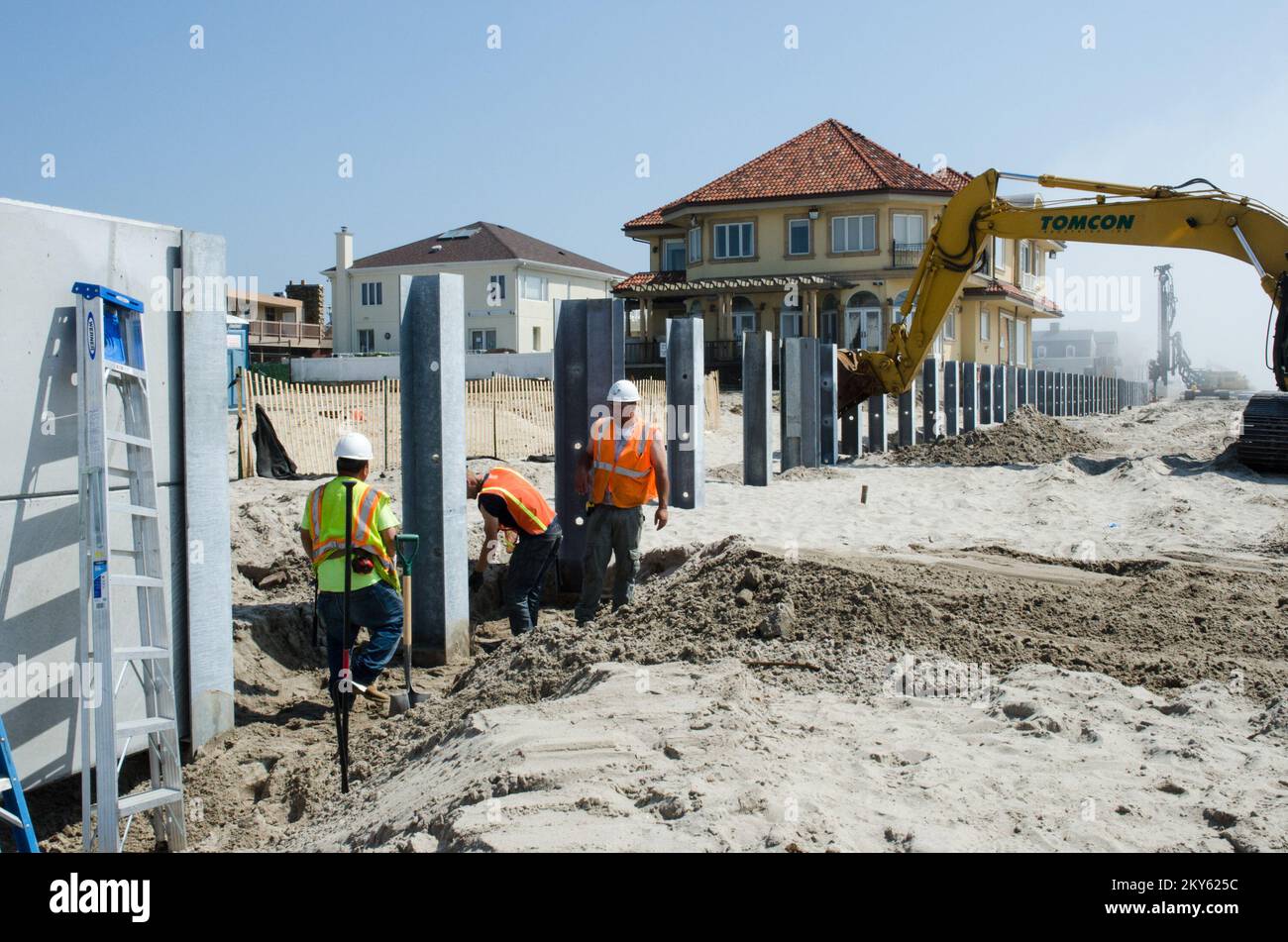 Belle Harbour, N.Y., 21 mai 2013 le département des parcs de la ville de New York, avec un financement partiel du programme d'aide publique de la FEMA, construit un mur-chicane dans les Rockaways, de la rue Beach 126th à la rue Beach 149th, pour remplacer l'ancien mur endommagé pendant l'ouragan Sandy. Les travailleurs installent des pidings en acier « H » entraînés à une profondeur de 25 pieds pour accroître la stabilité. Le mur du déflecteur se trouve à quatre pieds au-dessus du niveau de la rue. K.C.WILSEY/FEMA. New York ouragan Sandy. Photographies relatives aux programmes, aux activités et aux fonctionnaires de gestion des catastrophes et des situations d'urgence Banque D'Images