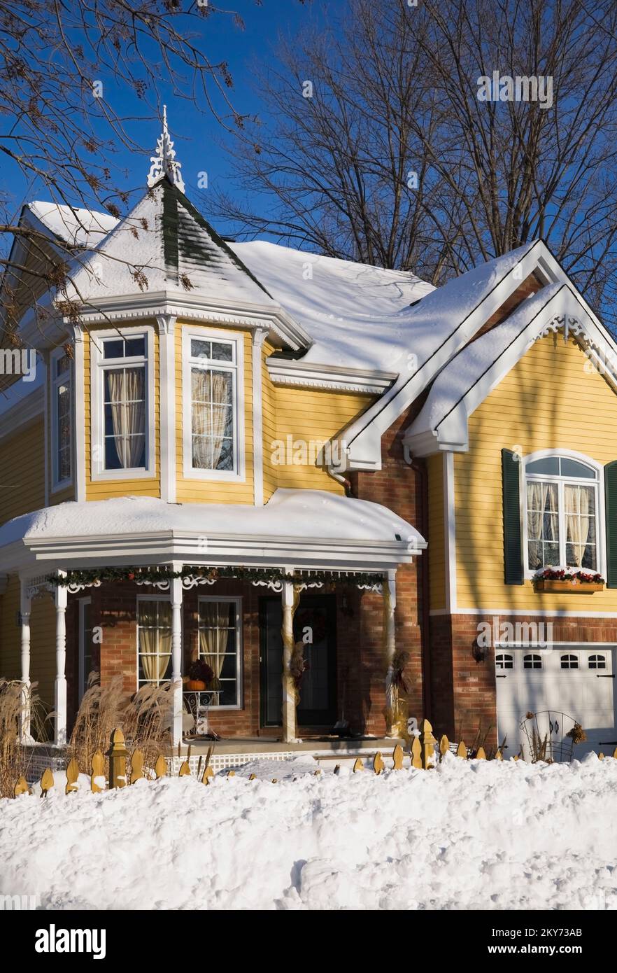Briques nuancées rouges et jaunes avec bordure blanche et verte deux étagés style victorien maison en hiver. Banque D'Images