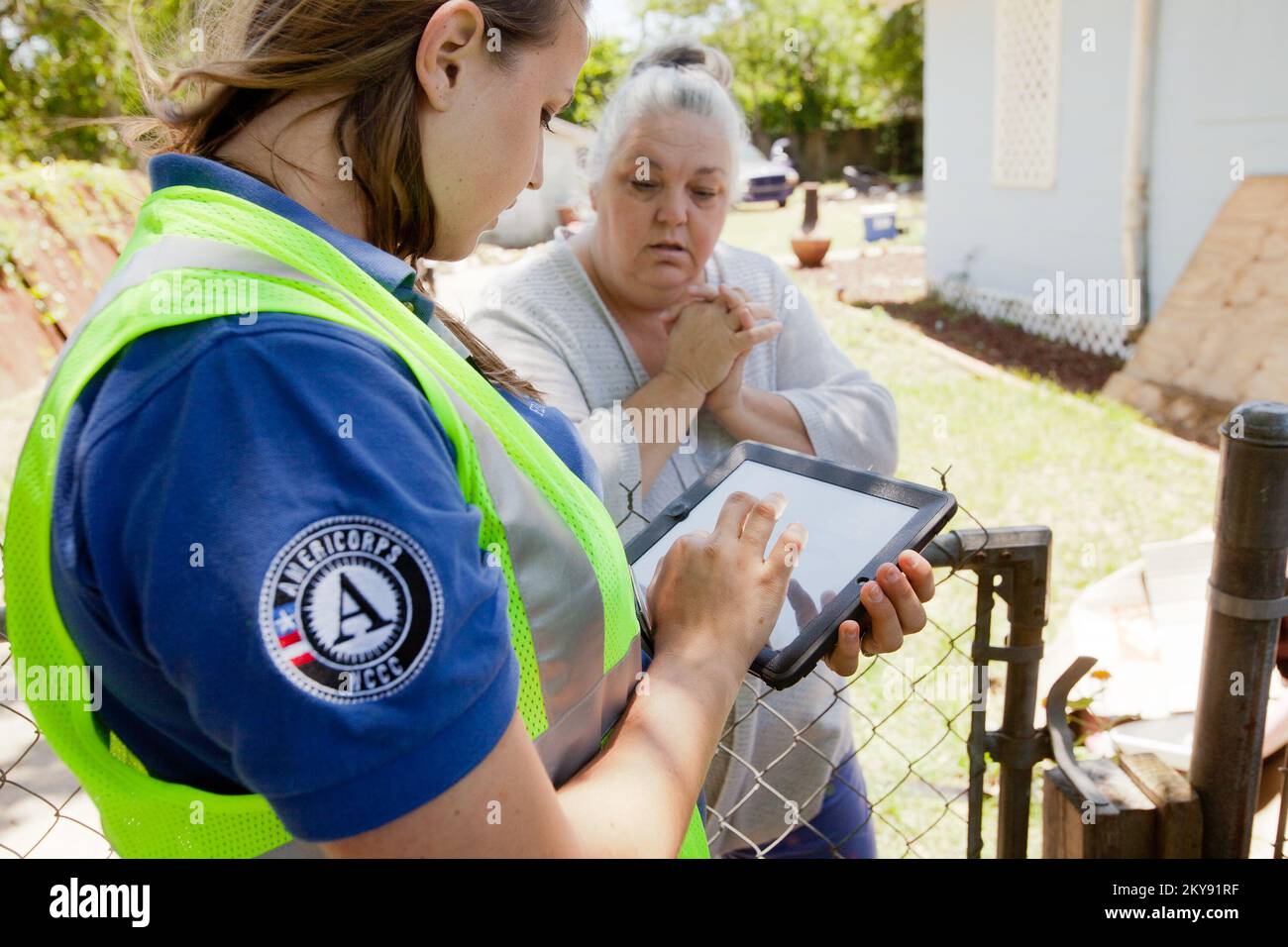 Pensacola, FL, 15 mai 2014 Marie Orechoff, membre de l'équipe d'aide aux survivants en cas de catastrophe, vérifie le statut de la demande de la FEMA de Toni Talley, à Brownsville, en Floride. Andrea Booher/FEMA. Floride tempêtes sévères, tornades, vents en ligne droite et inondations. Photographies relatives aux programmes, aux activités et aux fonctionnaires de gestion des catastrophes et des situations d'urgence Banque D'Images