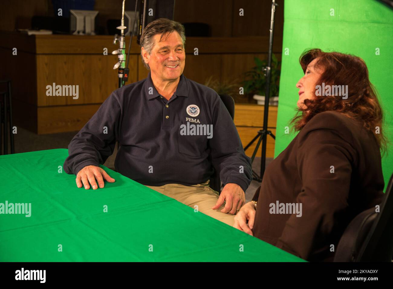 St. Clair Shores, MI, 23 octobre 2014 - Mary Jane d'Hperde (à droite), directrice des communications de St. Clair Shores (Michigan), interview Dolph A. Diemont (à gauche), officier de coordination fédéral (FCO) de la FEMA, contre un écran vert dans le studio de télévision de St. Hôtel de ville de clair Shores au sujet de l'aide aux survivants d'une catastrophe à la suite des violentes tempêtes et des inondations sur 11-13 août 2014 qui ont eu des répercussions négatives sur les comtés de Wayne, Oakland et Macomb. La FEMA soutient les gouvernements locaux et étatiques et les entités tribales dans leurs efforts pour se remettre des catastrophes naturelles. Tempêtes et inondations graves au Michigan Banque D'Images