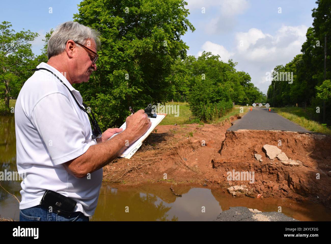 KIRK Lensgraf, spécialiste de projet FEMA PA, évalue les dommages causés à un pont au-dessus du ruisseau Bessie dans le comté de Waller, Texas. Le pont s'est effondré lorsque le ponceau sous la route s'est lavé dans le 17 avril par la tempête de 24, 2016. Lensgraf et deux autres spécialistes de l'aide publique de la FEMA fournissent des évaluations des dommages à la FEMA en contrepartie de la demande d'aide publique du comté de Waller. Texas : tempêtes et inondations graves. Photographies relatives aux programmes, aux activités et aux fonctionnaires de gestion des catastrophes et des situations d'urgence Banque D'Images