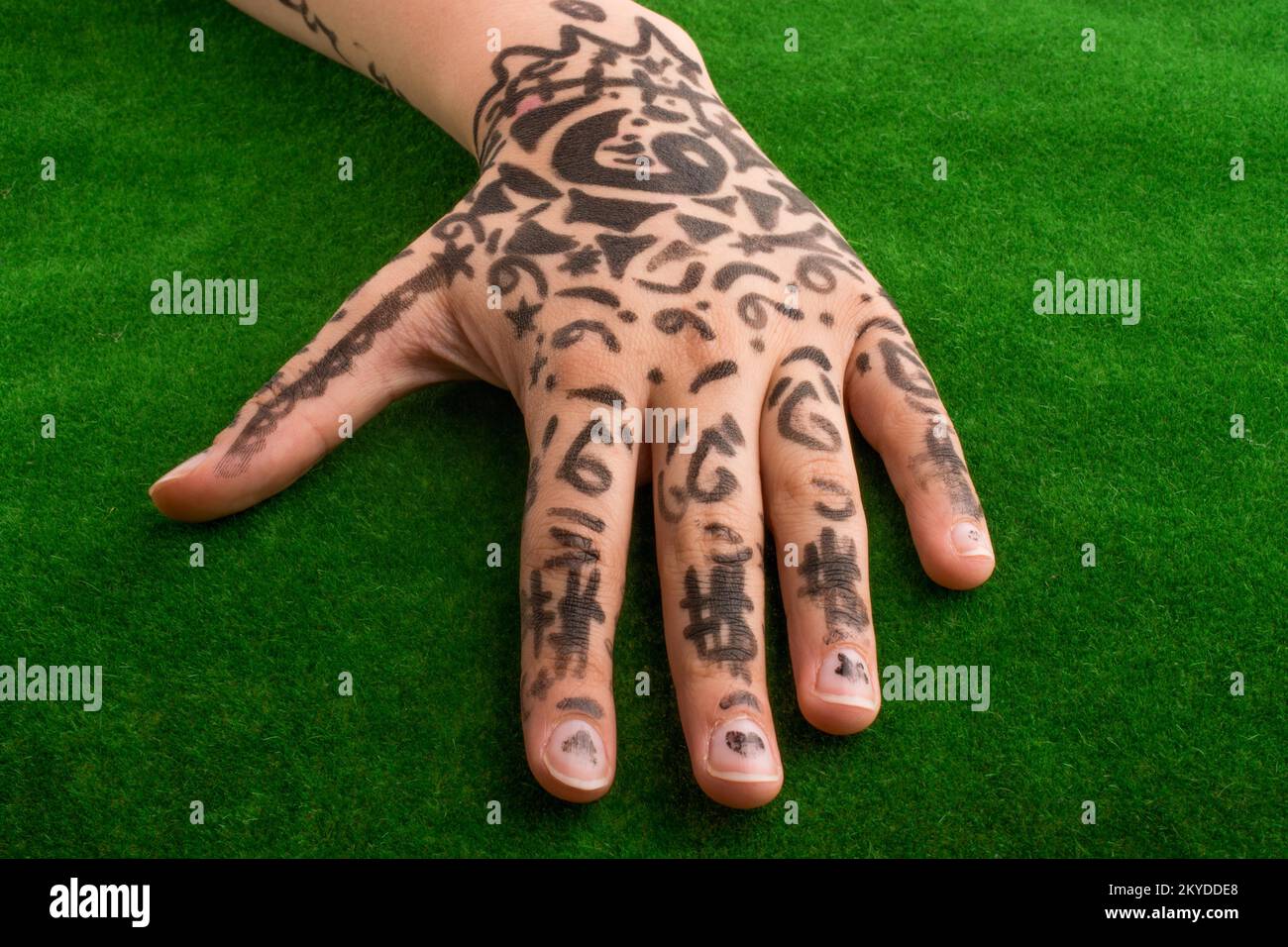 La main avec tattoo on Green grass Banque D'Images