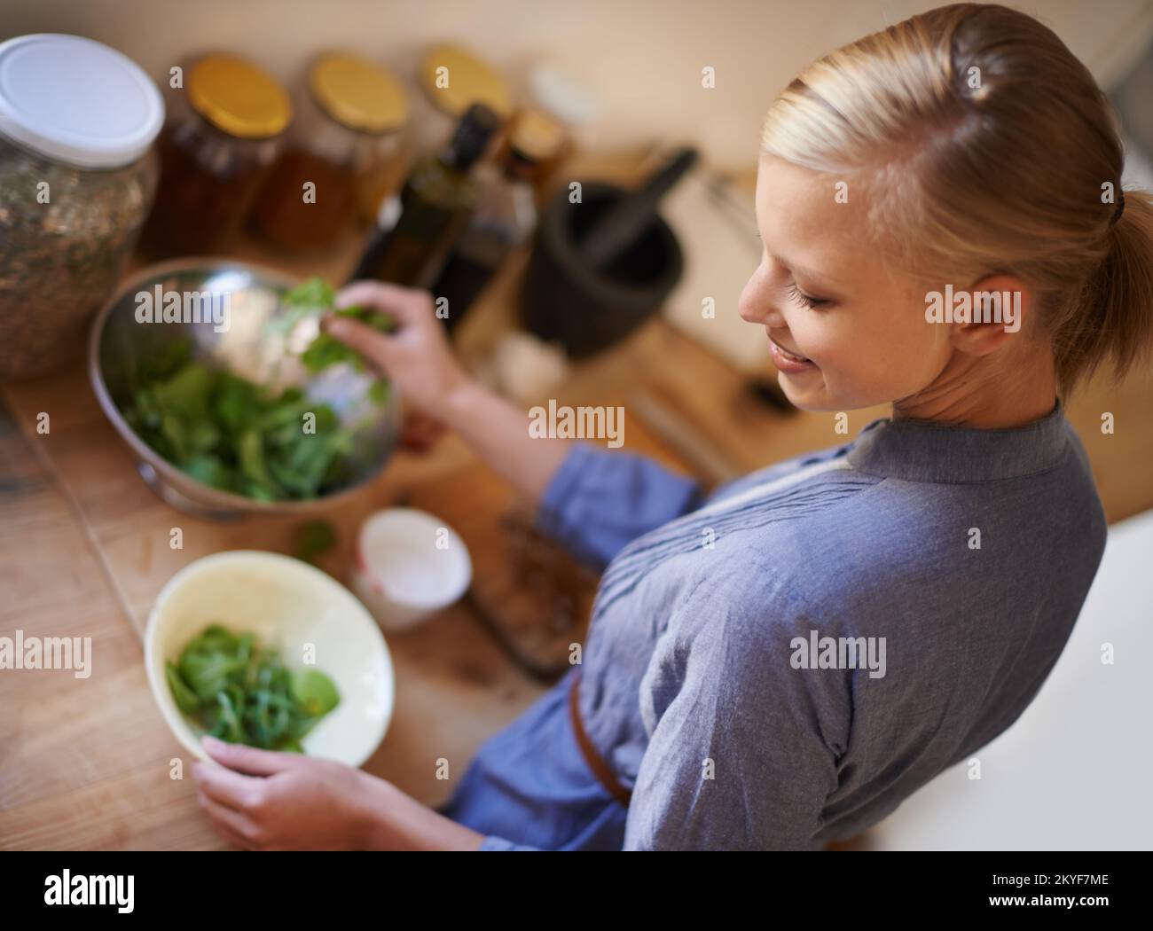 Fait avec amour et soin. Photo en grand angle d'une femme préparant une salade dans une cuisine. Banque D'Images