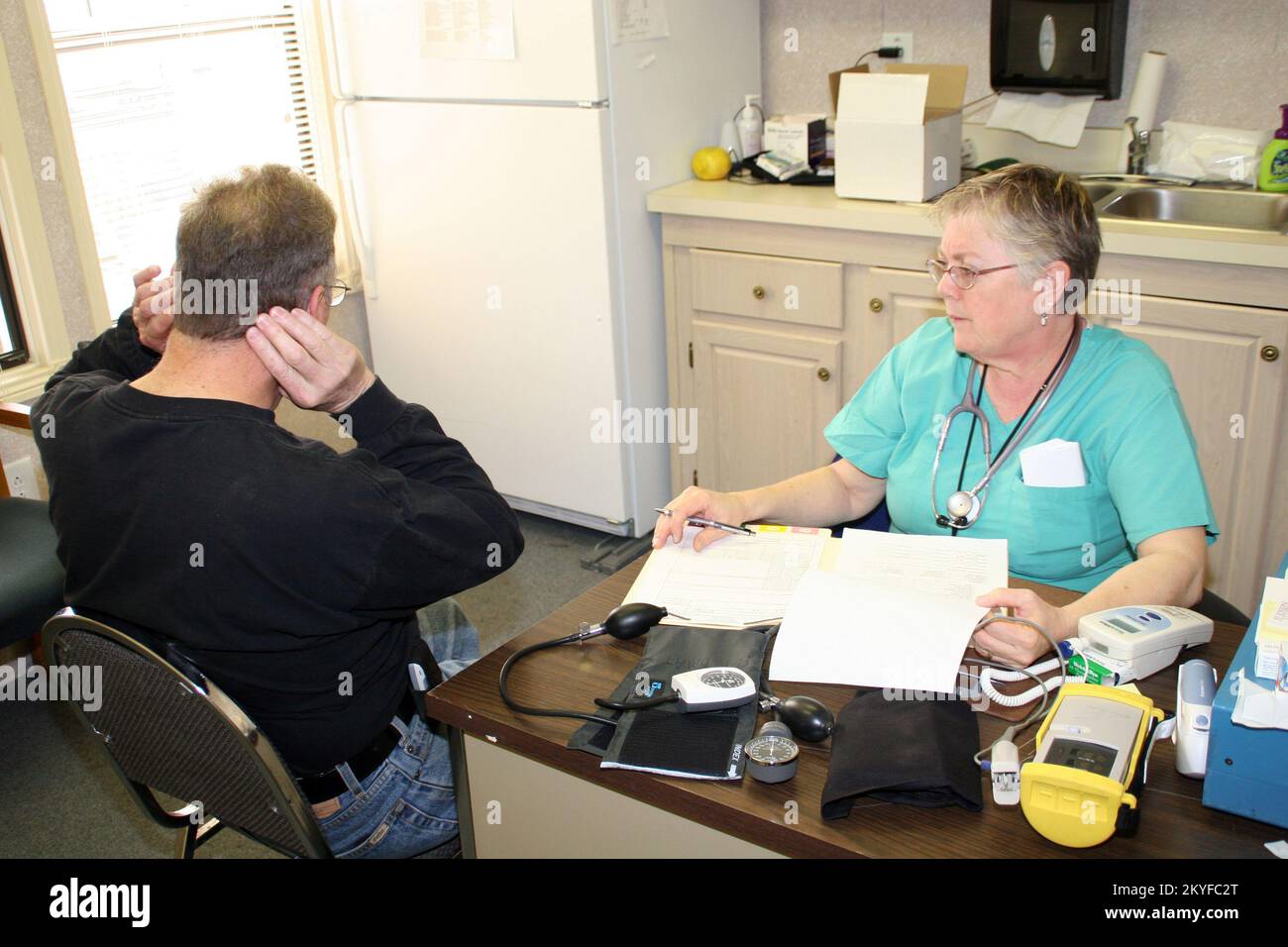 Ouragan Katrina, Chalmette, LA, 16 décembre 2005 - Un patient décrit ses symptômes avec une infirmière à la clinique de soins primaires de St. Paroisse de Bernard. L'établissement situé dans une remorque de bureau à triple largeur offre des soins médicaux gratuits aux résidents de la région, avec du personnel des États-Unis Agence de la santé publique du Canada et l'équipe d'aide médicale en cas de catastrophe de la FEMA (DMAT). Robert Kaufmann/FEMA Banque D'Images