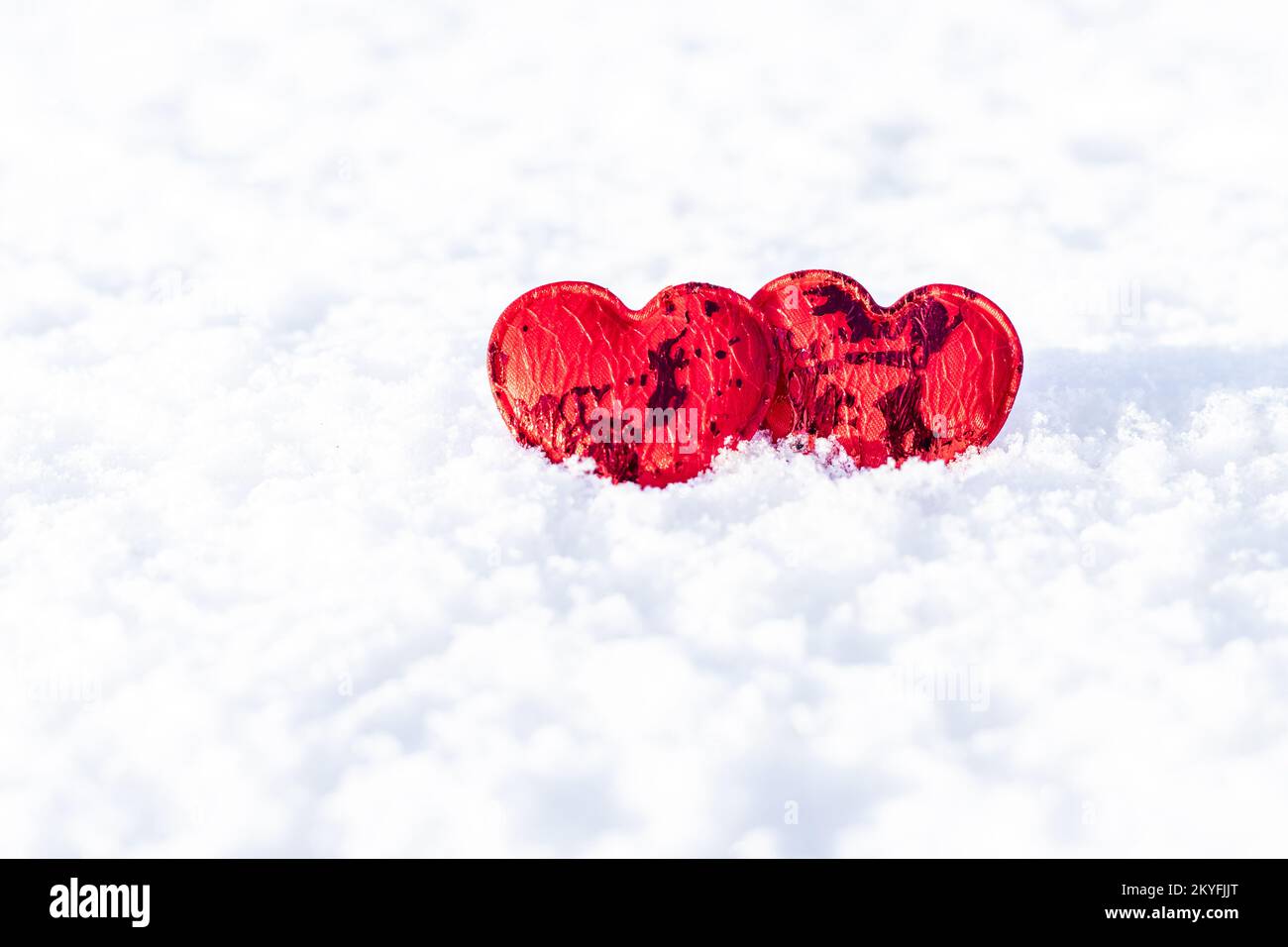 Concept de la Saint-Valentin. Deux coeurs rouges sur fond de neige blanche gros plan. copyspace Banque D'Images