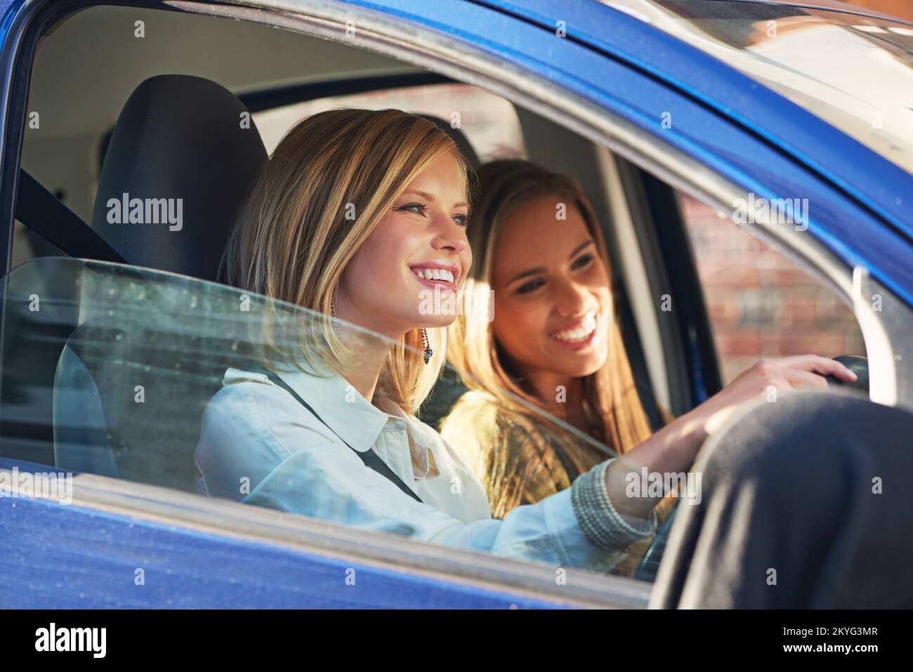 Il est temps de rejoindre le centre commercial. deux jeunes femmes voyageant en voiture dans la ville. Banque D'Images