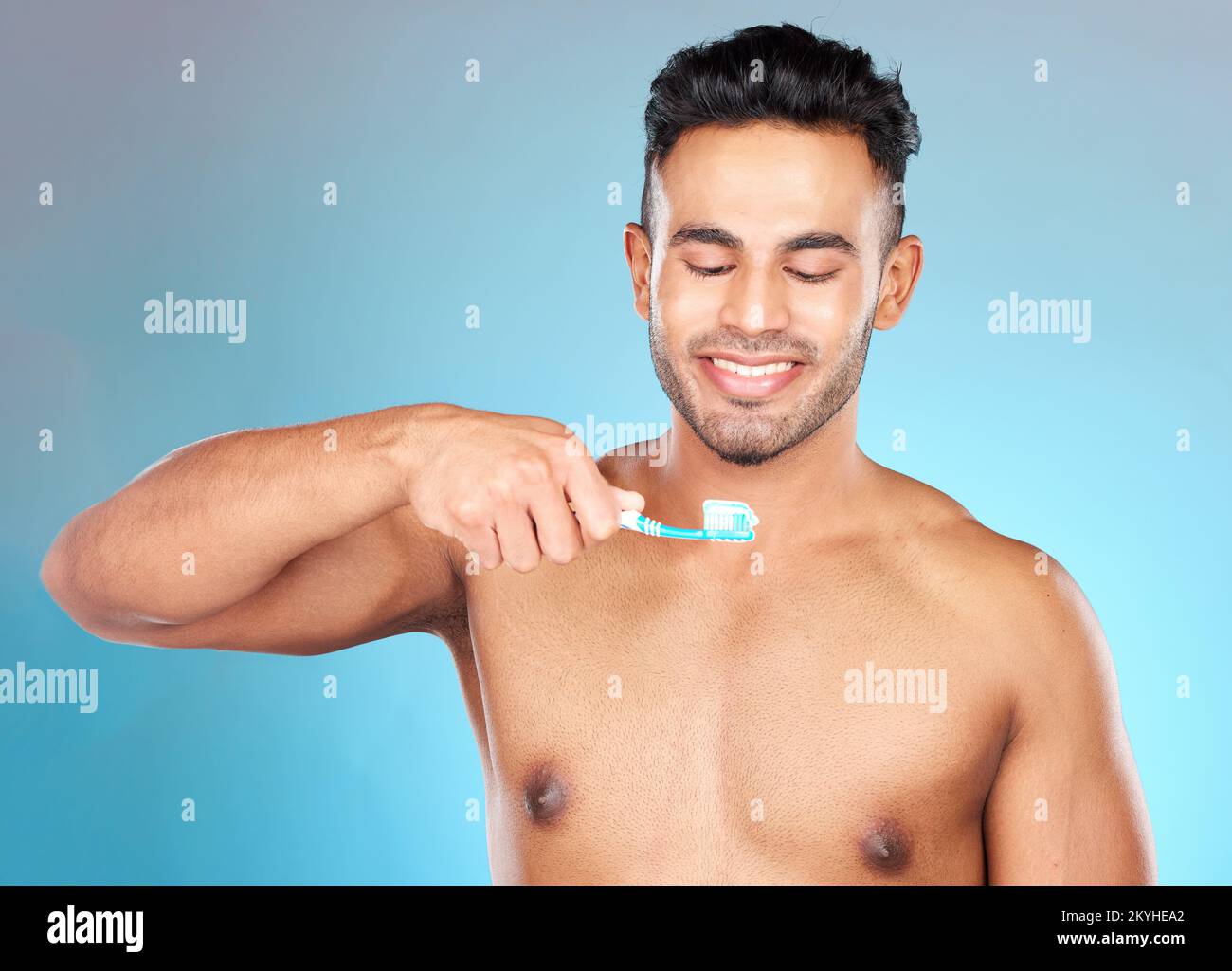 Dents, soins dentaires et homme se brossant les dents avec une brosse à dents et un dentifrice sur fond bleu avec le sourire sur le visage. Matin, soins de santé et frais Banque D'Images