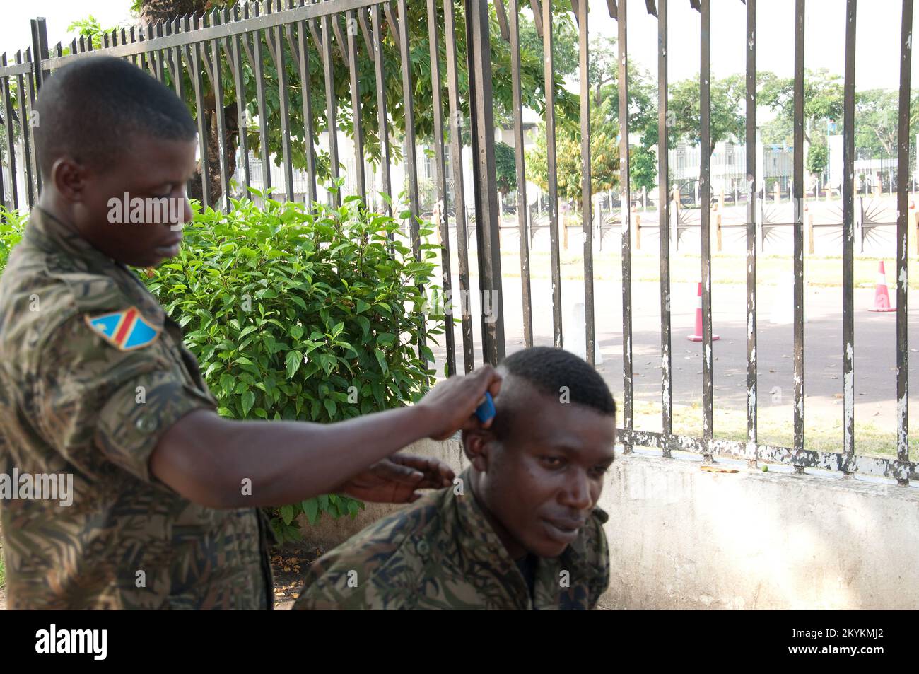 Un soldat qui obtient une coupe de cheveux, Kinshasa, République démocratique du Congo - avec un rasoir et un peigne Banque D'Images
