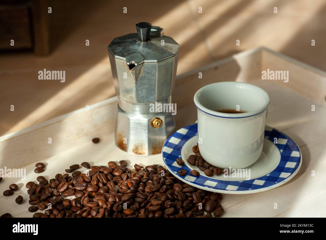 Cafetière italienne, tasse avec café frais et grains de café bruns sur un  plateau en bois pour un petit déjeuner avec les premiers rayons du soleil  Photo Stock - Alamy