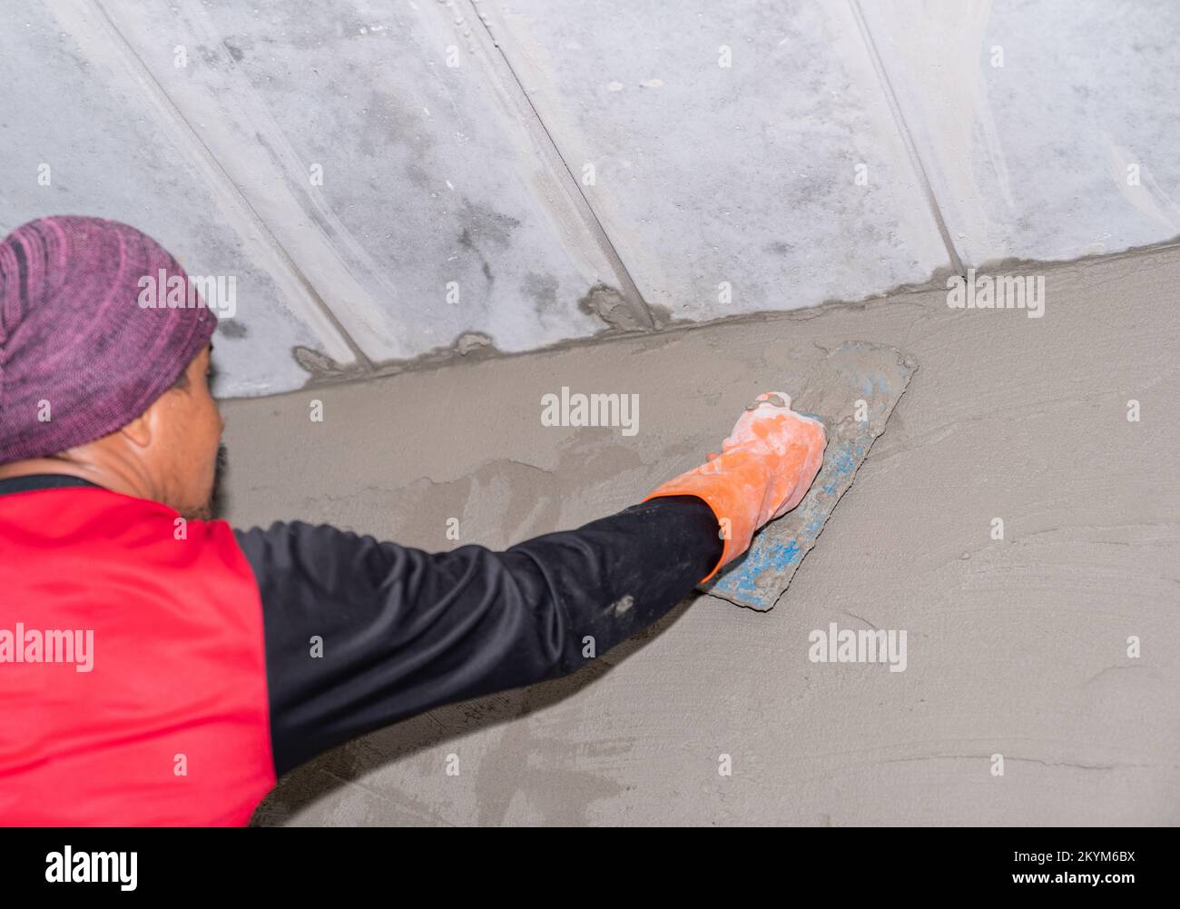 Un employé plâtrage à l'intérieur du mur sur le chantier. Banque D'Images