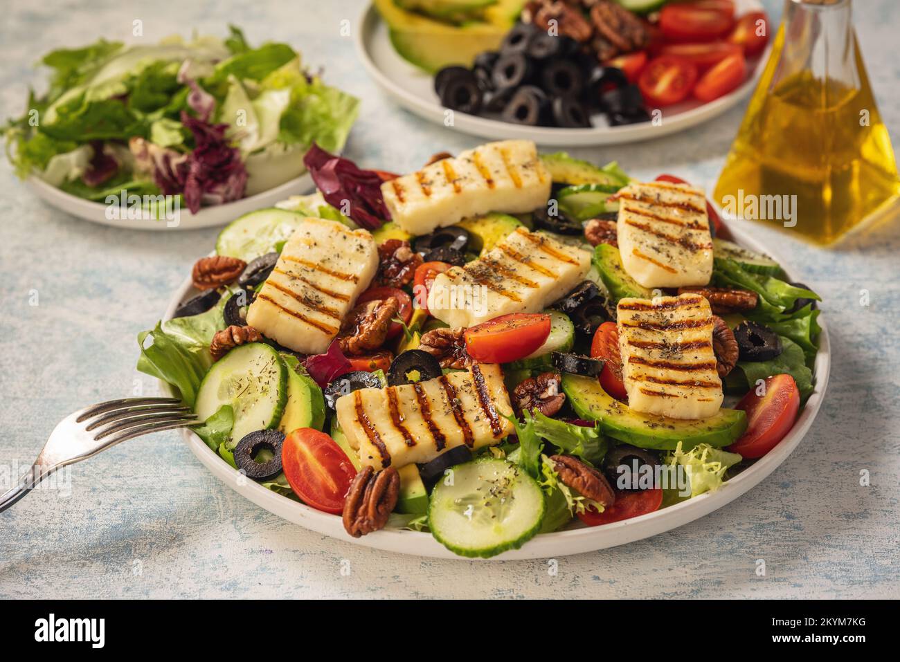 Cuisine grecque - salade avec fromage d'halloumi grillé, avocat, noix de pécan et tomates. Banque D'Images